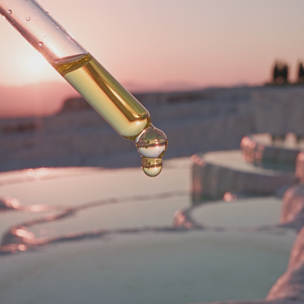 Nuvana film: a golden drop falls from the pipette, six women, a seed splitting and rosemary, drops along the part, and the Root Complex bottle held up at a pink lake