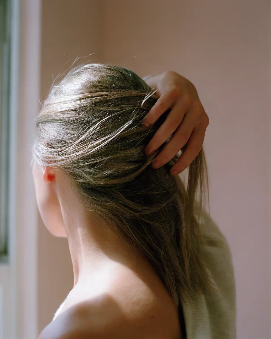 A woman running her fingers back through clean, soft, dry hair